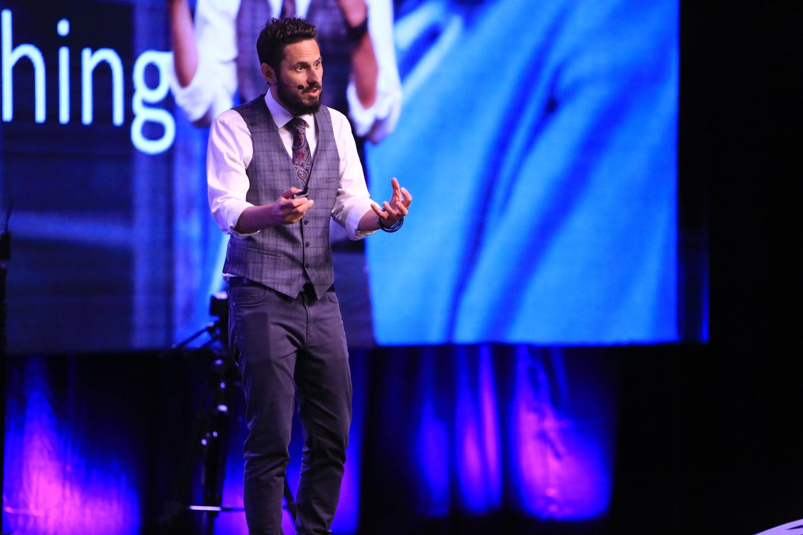 A speaker presenting on stage at an Objectivist conference
